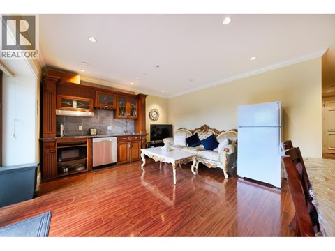 A living room with a white sofa and wooden floors.