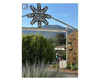A large sun-like sign with a real estate logo on it.