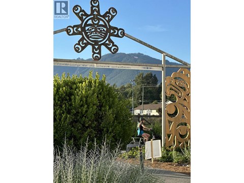 A large sun-like sign with a real estate logo on it.