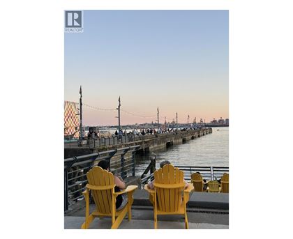 Two yellow chairs are on a dock with a pier in the background.