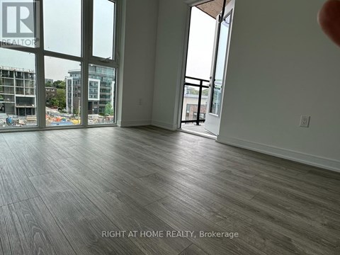 A room with a view of a construction site through the windows.