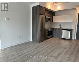 A kitchen with a refrigerator, microwave, oven, and dishwasher.