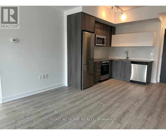 A kitchen with a refrigerator, microwave, oven, and dishwasher.