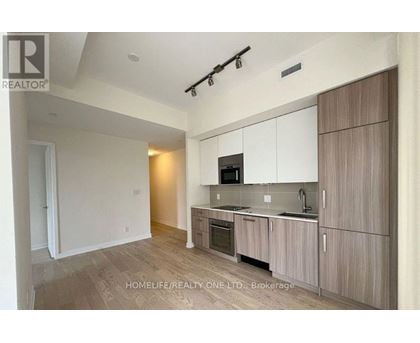 A modern kitchen with wooden cabinets and a microwave above the stove.