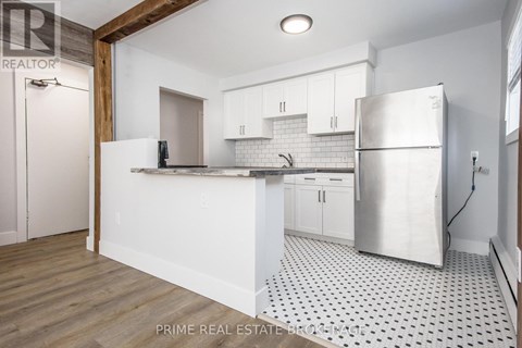A kitchen with white cabinets and a black and white floor.