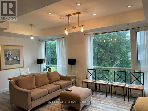 A living room with a couch, a table, and a painting on the wall.
