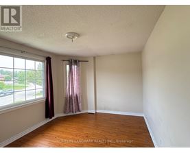 A room with a window and a wooden floor.