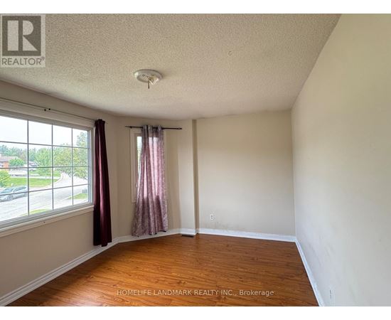 A room with a window and a wooden floor.