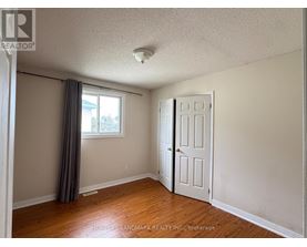 A room with a white door and a window with a grey curtain.