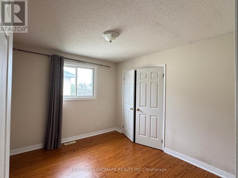 A room with a white door and a window with a grey curtain.