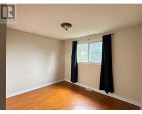 A room with a window and black curtains.
