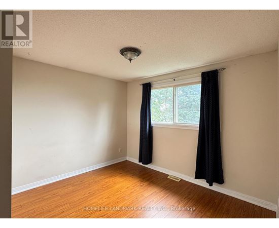 A room with a window and black curtains.