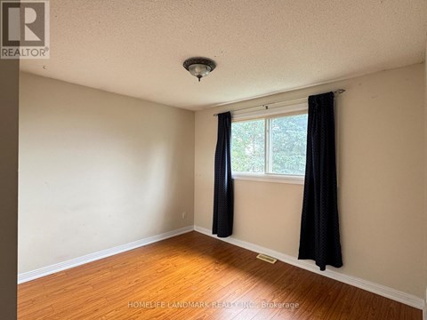 A room with a window and black curtains.