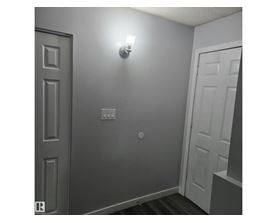A white door is on the left and a light is on the wall.