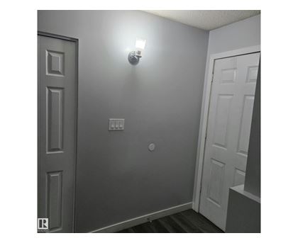A white door is on the left and a light is on the wall.