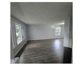 A room with wooden flooring and white walls.
