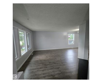 A room with wooden flooring and white walls.