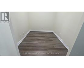 A room with wooden flooring and white walls.