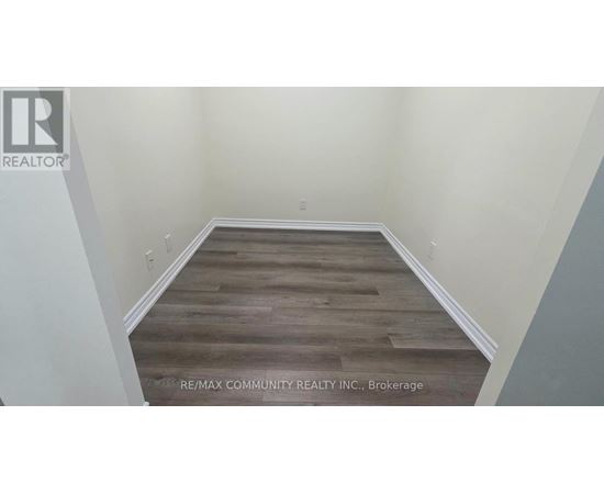 A room with wooden flooring and white walls.