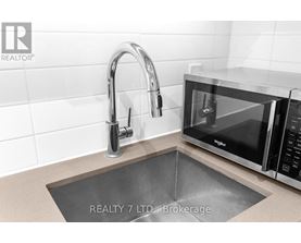 A modern kitchen with a sink and a microwave.