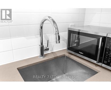 A modern kitchen with a sink and a microwave.