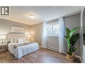 A bedroom with a large bed and a potted plant.