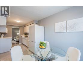 A modern kitchen with a glass table and white chairs.