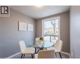 A dining room with a glass table and four chairs.