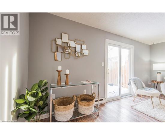 A modern living room with a glass table and a mirrored wall art.