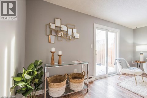 A modern living room with a glass table and a mirrored wall art.