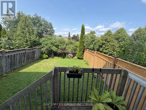 A backyard with a wooden fence and a potted plant.