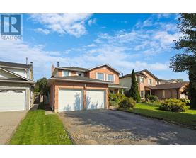 A large, well-maintained house with a driveway in front is for sale.