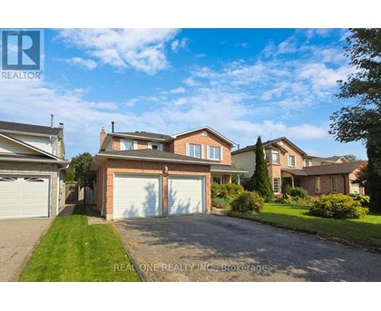 A large, well-maintained house with a driveway in front is for sale.