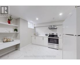A white kitchen with a refrigerator, oven, and shelves.