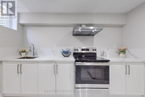 A white kitchen with a stove and cabinets.