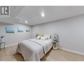 A bedroom with a bed, nightstand, and two pictures on the wall.