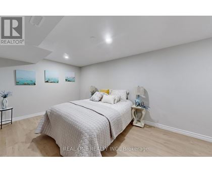 A bedroom with a bed, nightstand, and two pictures on the wall.
