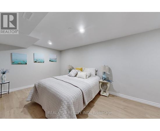 A bedroom with a bed, nightstand, and two pictures on the wall.