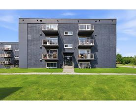 A large grey building with balconies and windows.