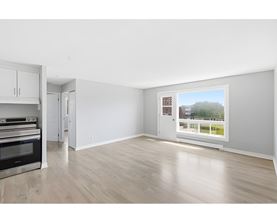 A spacious room with a view of a green area outside the window.