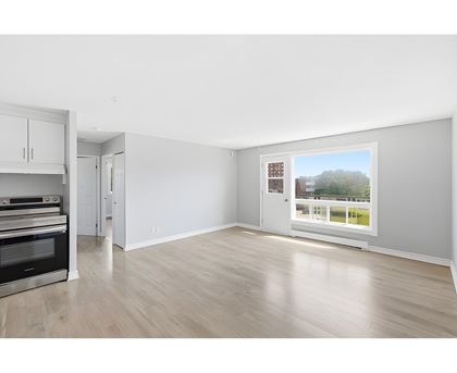 A spacious room with a view of a green area outside the window.