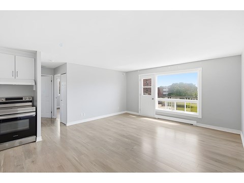 A spacious room with a view of a green area outside the window.