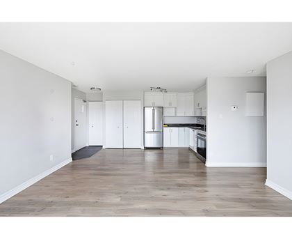 A kitchen with white cabinets and a wooden floor.
