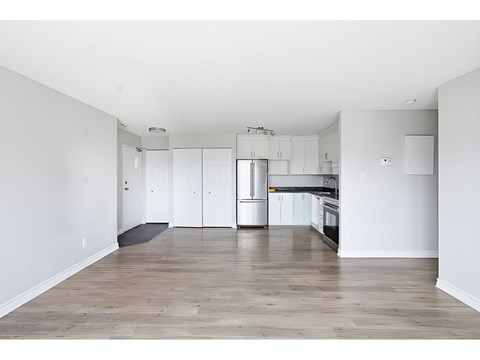 A kitchen with white cabinets and a wooden floor.