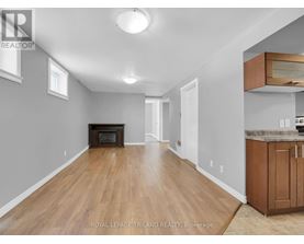 A spacious room with wooden floors and a fireplace.