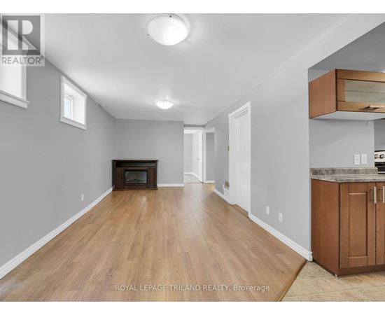 A spacious room with wooden floors and a fireplace.