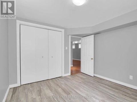 A white door is in a room with wood flooring.