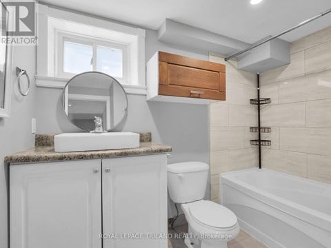 A white toilet sits next to a bathtub in a bathroom.