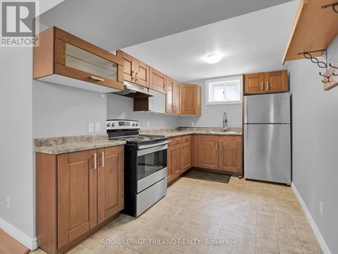 A kitchen with wooden cabinets and a black stove top oven.