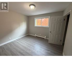 A room with a door, window, and a wall-mounted air conditioner.